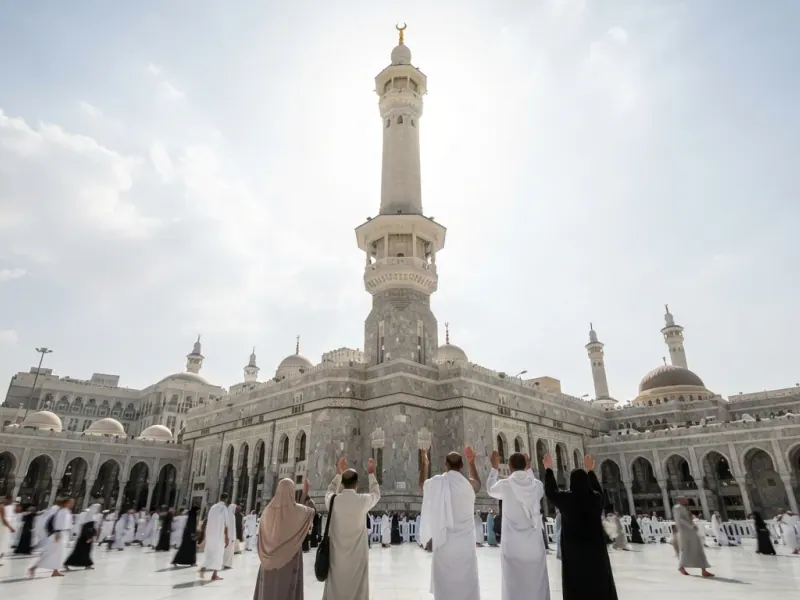 Mescid-i Haram avlusunda dua eden hacılar ve minare